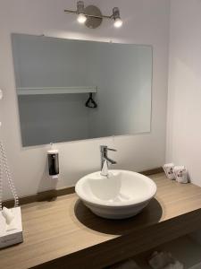 MetabetchouanMotel Le Rond Point的浴室设有白色水槽和镜子