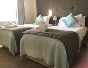 Fenay BridgeWoodsome Hall Golf Club Dormy House的两张位于酒店客房的床,配有毛巾