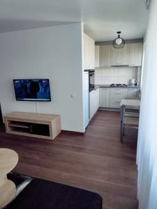 希奥利艾Trumpalaikė nuoma centre的一间厨房,配有白色橱柜和墙上的电视