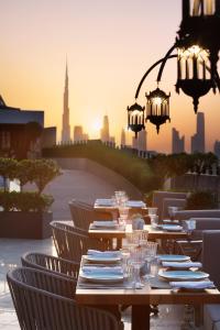 迪拜Occidental Al Jaddaf, Dubai的城市前的桌子,带盘子和酒杯
