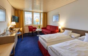 巴特莱辛哈尔巴伐利亚健康活力酒店的酒店客房,配有一张床和一张红色椅子