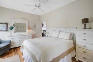 富丽海滩Beachwalk Villas 23的一间白色卧室,配有一张床和一个梳妆台