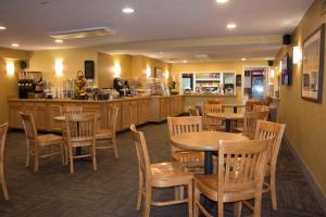 西雅茅斯碧沙度假酒店的餐厅设有木桌、椅子和柜台
