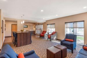 林肯Comfort Inn & Suites near Route 66的一间带蓝色家具的客厅和一间厨房