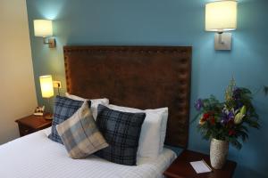 斯佩河畔格兰敦克瑞拉克莱格林恩酒店的一间卧室配有带枕头的床铺和蓝色的墙壁