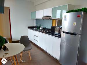 利马Residencial Cafferata的厨房配有不锈钢冰箱和白色橱柜