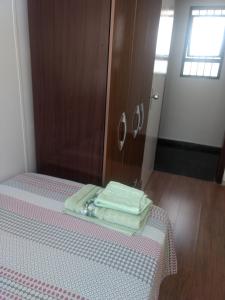 伊图Quartos Masculino - Romas House的床上有两张折叠毛巾