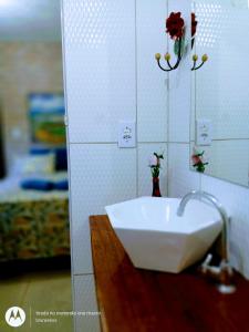 伦索伊斯Suites Casa De Ban的墙上设有带鲜花水槽的浴室