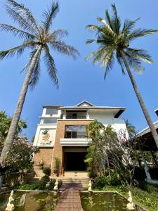 盼武里金松滩海滩度假酒店的两棵棕榈树的建筑