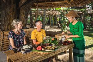内维桑艾斯卡拉度假村的一群人坐在餐桌旁吃着食物