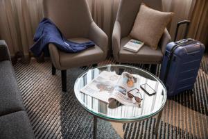 悉尼诺富特悉尼帕拉马塔酒店的客厅配有两把椅子和一张玻璃桌