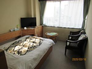 伊势市伊势6号每周公寓式酒店的一间卧室配有一张床、一张书桌和一台电视