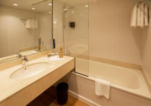 里乌德洛茨·德拉塞尔布拉瓦伊甸园酒店的浴室配有水槽、淋浴和浴缸。