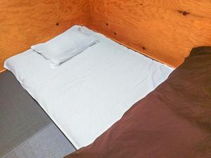 东京ゲストハウス高円寺純情ホテル -Guest House Koenji Junjo Hotel-的一张带白色床单和枕头的床