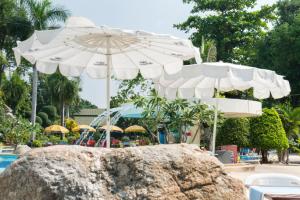 乔木提恩海滩乔木提恩皇宫大酒店 - SHA Extra Plus的一组太阳伞坐在游泳池旁