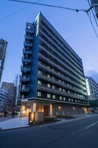 仙台R&B Hotel Sendai Higashiguchi的街道边的蓝色大建筑