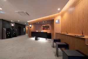 仙台R&B Hotel Sendai Higashiguchi的大堂设有1间带桌椅的等候室