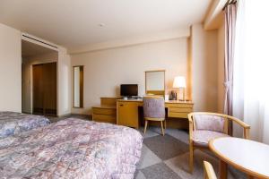 南砺缪克斯福冈镇酒店的酒店客房带一张床、一张桌子和椅子