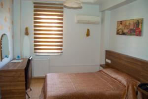 加济安泰普尤努斯酒店的一间卧室配有一张床、一张书桌和一个窗户。