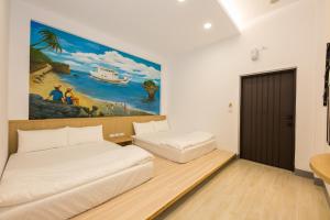 小琉球岛小琉球八八民宿的一间设有两张床的客房,墙上挂着一幅画