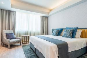 哈拉雷彩虹大厦酒店及会议中心 的酒店客房带一张大床和一把椅子