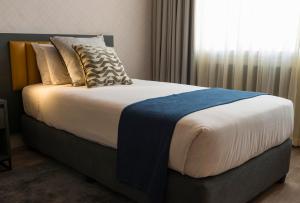 哈拉雷彩虹大厦酒店及会议中心 的一间卧室设有一张大床和窗户