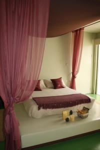 Argamasilla de AlbaLuz de Alba的一间卧室配有一张带粉红色窗帘的大床