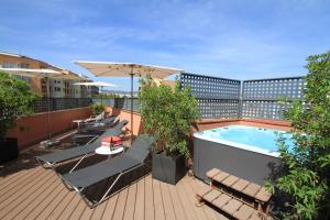 巴塞罗那Garbi Millenni的阳台设有游泳池、椅子和遮阳伞。