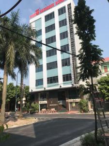 北宁恒波克酒店的街道前有棕榈树的建筑