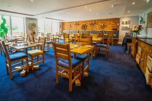 索利赫尔The Limes Country Lodge Hotel & Admiral Restaurant的餐厅设有木桌和椅子,拥有砖墙