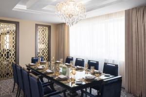 布赖代卡西姆瑞享酒店的一间带桌椅和吊灯的用餐室