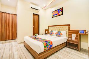 孟买FabHotel Axis International的配有一张床和一张书桌的酒店客房