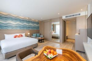 华欣Maven Stylish Hotel Hua Hin的酒店客房配有一张床铺和一张桌子。