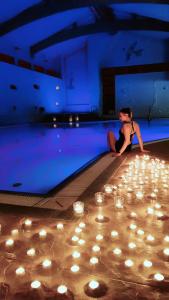 奥斯诺卢布斯基Afrodyta SPA & Wellness Resort的坐在带蜡烛的游泳池边的女人