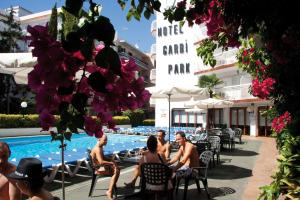罗列特海岸Hotel Garbi Park & AquaSplash的一群人坐在酒店游泳池周围