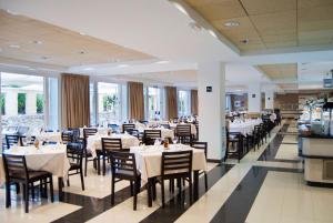 科尼尔-德拉弗龙特拉加比光之海岸酒店的一间设有白色桌椅的用餐室
