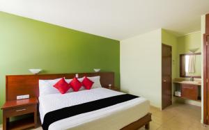乔卢拉Hotel San Pablo的一间卧室配有一张带红色枕头的大床
