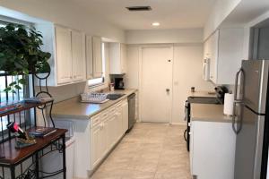 迈尔斯堡San Carlos Paradise!的厨房配有白色橱柜和冰箱。