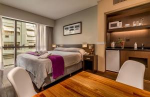 布宜诺斯艾利斯Up Viamonte Hotel的一间卧室配有一张床和两把白色椅子