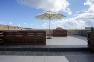 MġarrGetawayNpetto Private Duplex Maisonette with Jacuzzi Hot Tub的屋顶上的雨伞