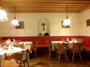 因斯布鲁克盖斯特夫奥尔伯格酒店的用餐室配有2张桌子和椅子以及灯光