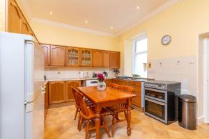 达夫敦Convalmore House的厨房配有桌椅和冰箱。