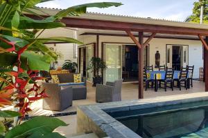 帕皮提Villa Oasis的一个带桌椅的庭院和一个游泳池