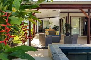 帕皮提Villa Oasis的庭院配有桌椅和一些植物