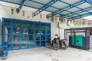 PulauberayanRedDoorz near Manhattan Square Medan的一辆摩托车停在一个有蓝色门的车库里