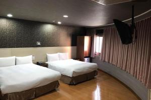 高雄龙翔商务大饭店的酒店客房设有两张床和电视。
