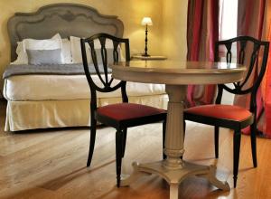法诺瑟瑞酒店的一张桌子和两把椅子,位于一个配有床的房间