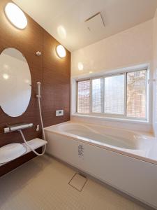 米原ゲストハウス メグルヤ 中山道柏原宿的带浴缸、卫生间和镜子的浴室