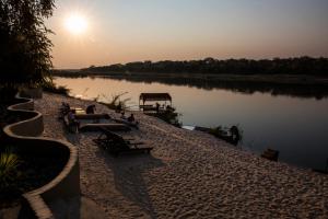 龙杜Hakusembe River Campsite的一群长椅坐在河边