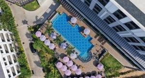 芭东海滩Sawaddi Patong Resort & Spa by Tolani - SHA Extra Plus的享有带椅子和遮阳伞的游泳池的上方景致